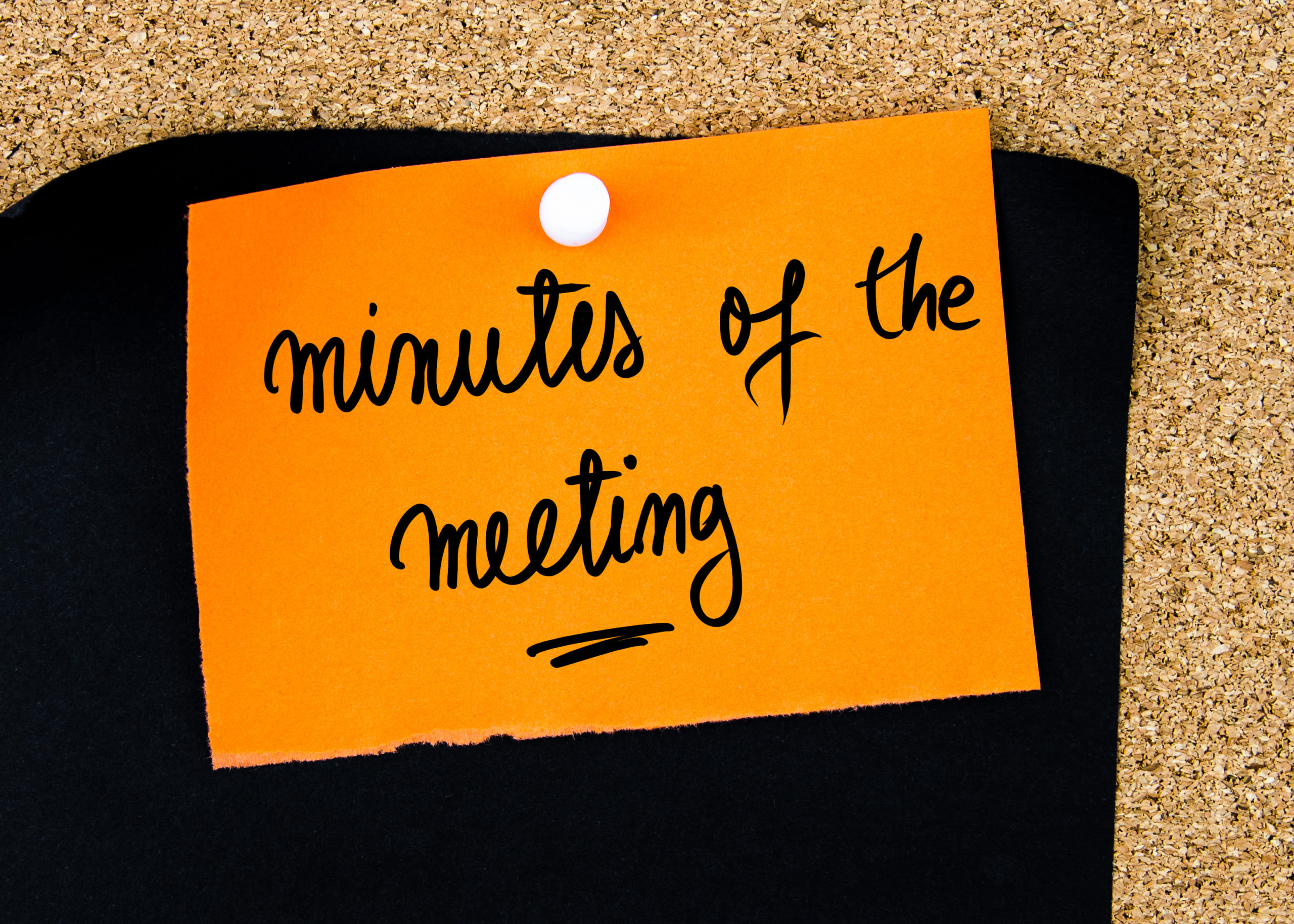 Minutes Of The Meeting written on orange paper note pinned on cork board with white thumbtacks, copy space available